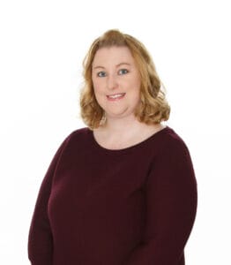 A woman in a maroon sweater poses for a photo at a wedding in Gettysburg, Pennsylvania.