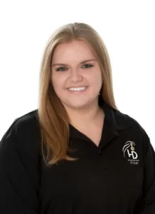 A woman in a black polo shirt, one of the wedding DJs in Gettysburg, Pennsylvania, smiling.