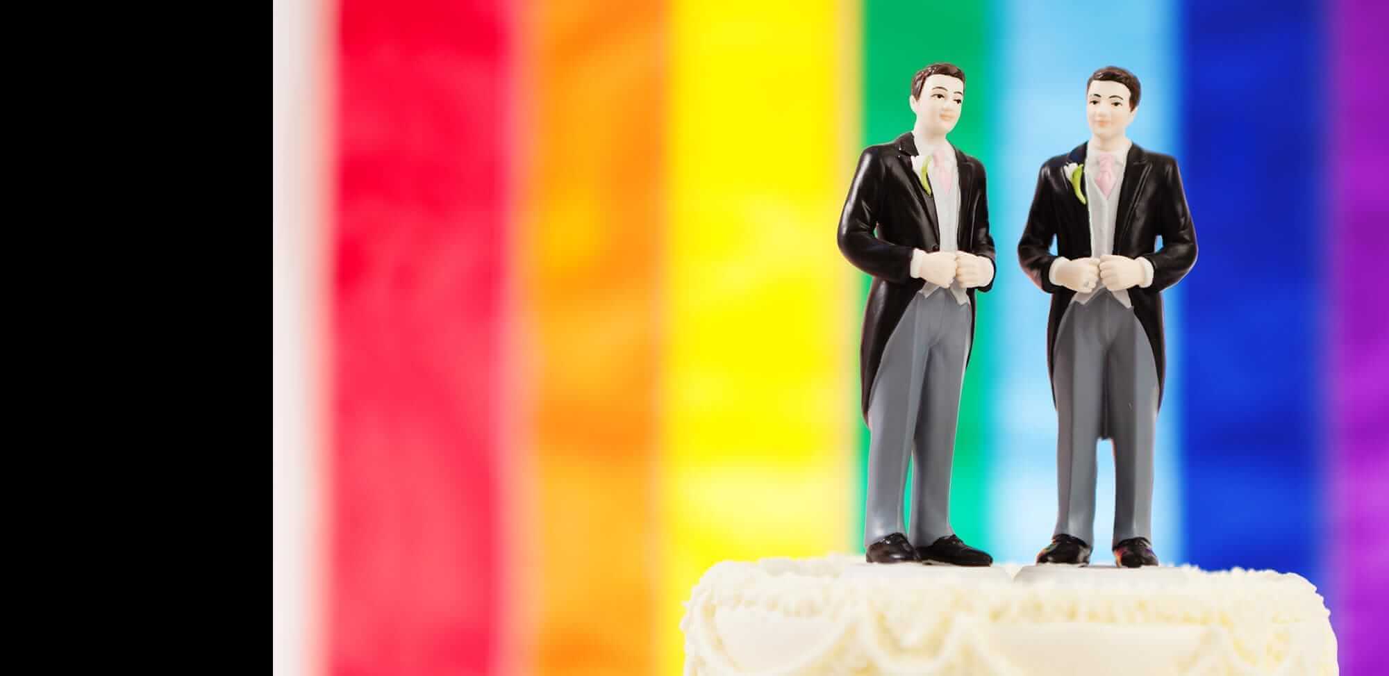 Two figurines on a cake with a rainbow background at a wedding in Gettysburg, Pennsylvania.